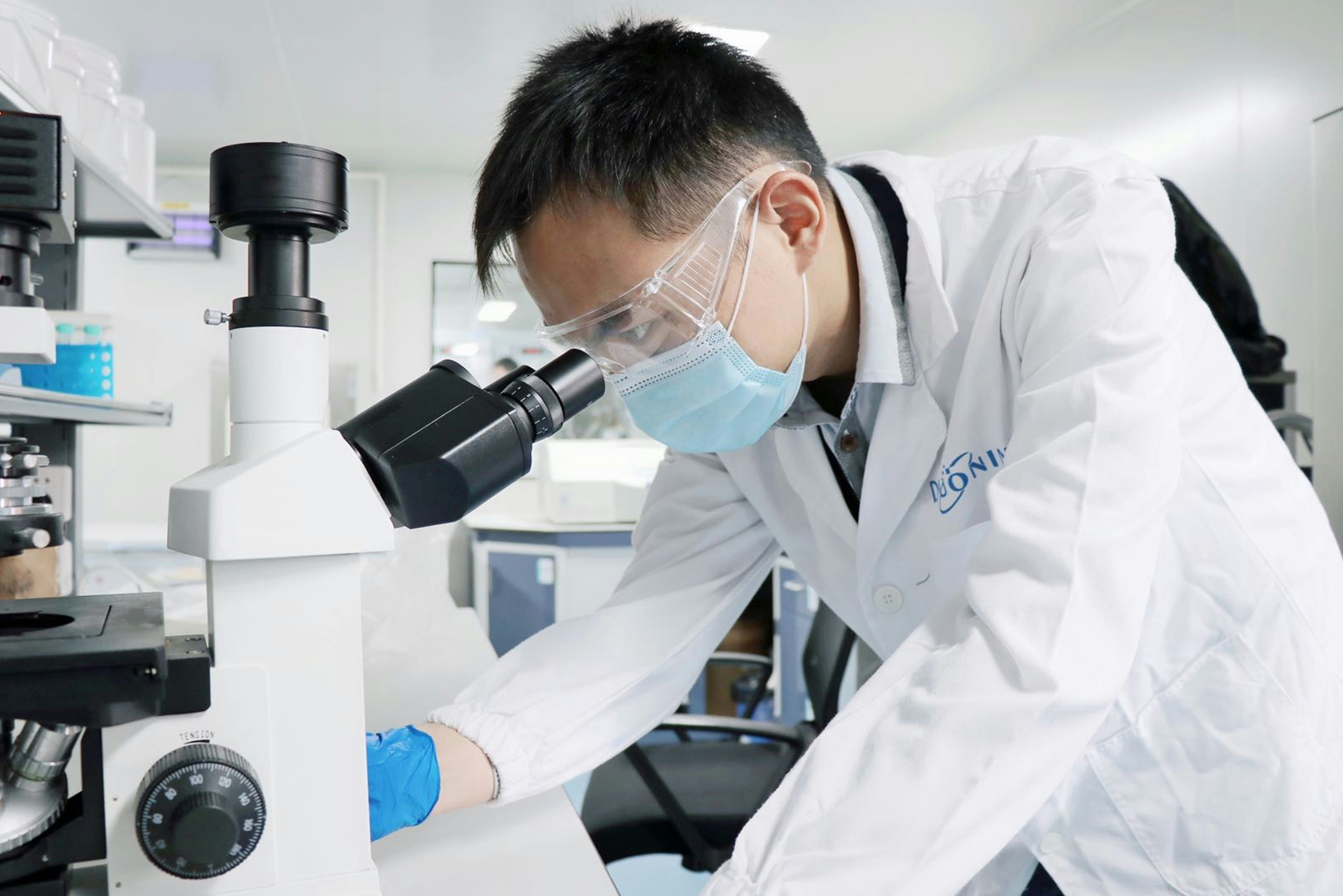 Researcher in life sciences laboratory with microscope